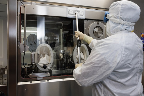 person in hazmat suit moping down metal door